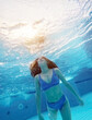 © Ievgen Skrypko - Teen girl swimming under water in blue pool. Pretty female teenager diving and enjoying summer activity