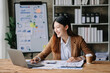 © Nuttapong punna - Asian businesswoman working in the office with working notepad, tablet and laptop documents .
