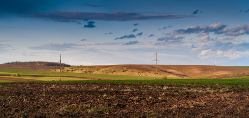 Wall Mural - A panoramic view of the arable soil before planting. a plowed field prepared for sowing crops and a hill in the spring.