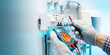 © Sergey - Electrician engineer work tester measuring voltage and current of power electric line in electrical panel. Banner with copy space.