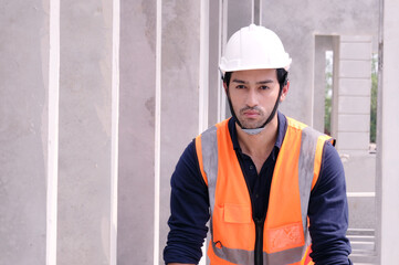 Young engineer in safety helmet standing at construction site building construction concept.