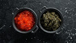 Set of red and black caviar in bowls. Premium caviar of high quality. On a black stone background. Top view.