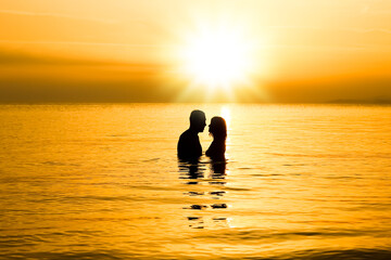 A happy couple in the sea on nature travel silhouette