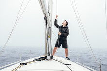 Focused Man Raising Sail On Yacht