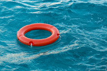 A Red Lifebuoy Floats On The Waves Of The Turquoise Sea.