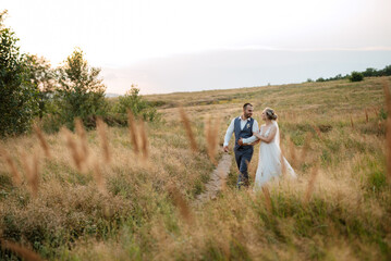 bride blonde girl and groom in a field