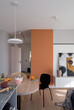 Dining table in apartment with orange wall