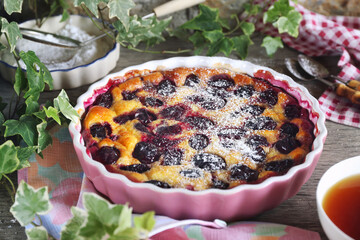 Wall Mural - Blue plum clafoutis (flan), icing sugar dressing and cup of tea