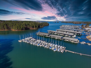 Wall Mural - aerial shot of the boats and yachts docked in the marina on the waters of Lake Lanier surrounded by lush green trees with powerful clouds at sunset in Buford Georgia USA