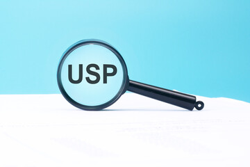 Poster - look at the text USP through a magnifying glass on a blue and white background