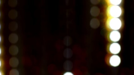 Wall Mural - Glowing dotted bokeh lines running down across a black background. 4K Loop. Abstract straight line dot run on the screen. Laser light dots stripe light technology background. Blur Light Circles.