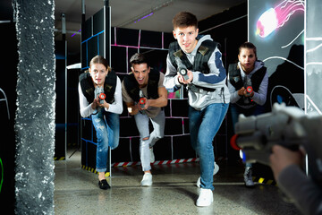 Canvas Print - Portrait of teenager boy with laser gun having fun on dark lasertag arena. High quality photo