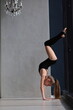 slim artistic teenage girl in black leotard training and leggings is training. rhythmic gymnastic exercise, children's professional sports