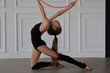 little sports girl doing exercises with a hula hoop