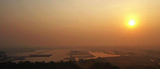 Solar Farm (solar cell) at sunset. Renewable green alternative energy. Power plant. Solar photovoltaic rows array of ground mount system Installation.