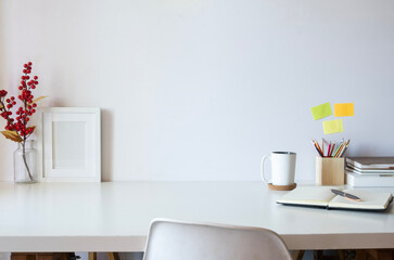Wall Mural - Comfortable workplace with books, picture frame, retro camera and coffee cup on white table. Copy space for text.