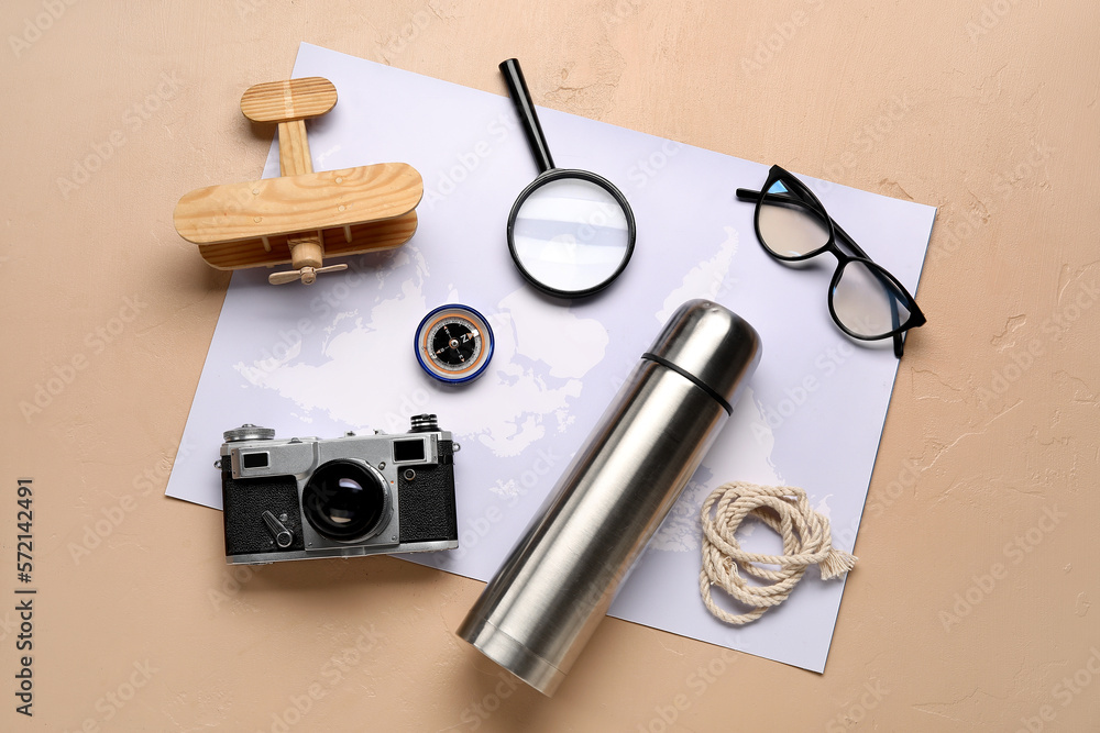 Compass with traveler accessories on beige background