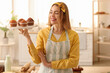 © Pixel-Shot - Female baker with tray of tasty cupcakes in kitchen