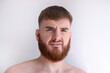 © Евгений Шемякин - portrait of unhappy unsatisfied young bearded handsome man with beard is looking at camera on white background.