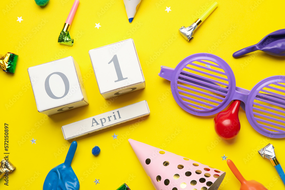Date 1 APRIL with party decor for Fools' Day celebration on yellow background