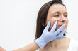 © Andrii - Photo of female face and hand in medical glove.
