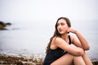 © Cavan Images - Young Woman at the Beach on a Rainy Day