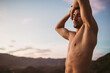 © Cavan Images - Attractive man stretching at sunset