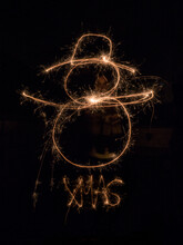 Young Girl Drawing Snowman With Sparkler