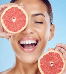 Wall Mural - Grapefruit, laughing and woman with face for beauty on studio background, wellness benefits and smile. Happy model, diet and citrus fruits for natural detox, healthy skincare and vitamin c aesthetic
