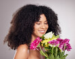 Beauty, skincare or black woman with flowers in studio for body wellness, luxury spa or self care. Aesthetic facial, happy model or girl relax with plants for treatment, cosmetics product or nature
