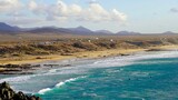Fototapeta  - Klify oceanu atlantyckiego w Fuertaventura morze woda i plaża, surferzy i góry