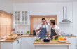 © Wosunan - A young couple enters the kitchen to prepare dinner for celebrating the anniversary of being together for many years
