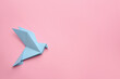 © New Africa - Beautiful light blue origami bird on pink background, top view. Space for text