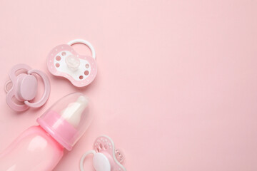 Wall Mural - Flat lay composition with pacifiers and other baby stuff on pink background. Space for text