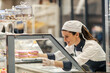 © Dusan Petkovic - A bakery worker is selling doughnuts at the supermarket.
