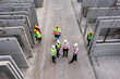 Aerial top view of architect and engineer discussing building plan at construction building site in warehouse factory. Precast concrete manufacturing products on prefabricated house factory	
