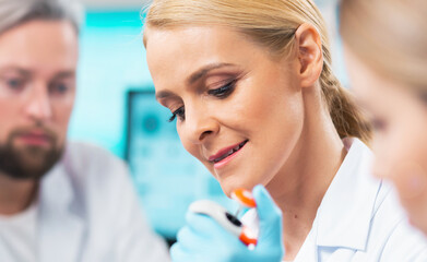 Wall Mural - Medical scientists working in lab. Doctor teaching interns to make analyzing research. Laboratory tools: microscope, test tubes, equipment. Science and health care concept.