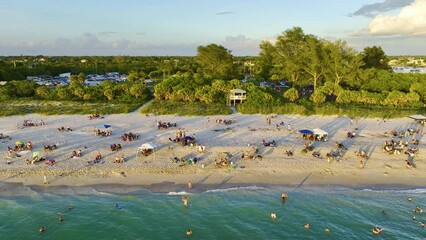 Canvas Print - Famous Siesta Key beach with soft white sand in Sarasota, USA. Many people enjoing vacation time bathing in warm gulf water and tanning under hot Florida sun at sunset