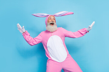 Sticker - Photo of good mood optimistic man dressed pink rabbit costume look empty space flying palms wings isolated on blue color background