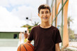 Portrait of a boy with a basketball on a basketball court. The concept of a sports lifestyle, training, sport, leisure, vacation