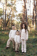 © Andriy Medvediuk - Portrait of happy adorable kids outdoors. Siblings, two stylish little brothers with their older sister hugging together in autumn park, smiling and looking at camera. Happy childhood concept