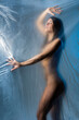 © ADDICTIVE STOCK - Naked woman standing behind cellophane