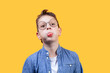 Portrait of a boy with glasses. He fools around and sticks out his tongue. Front view. Yellow background. Suitable for collage and banner making and other design