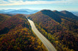 Empty free of vehicles I-40 freeway road leading to Asheville in North Carolina thru Appalachian mountains with yellow fall forest. High gas prices and energy crisis concept