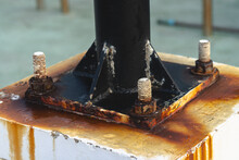 Close Up Of A Metal Pole Anchored On A Corroded And Rusted Steel Plate.