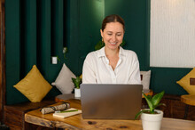 Positive Woman Using Laptop In Cafe