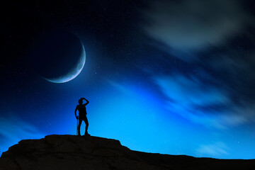 Wall Mural - Silhouette of a person standing on the full moon background.
