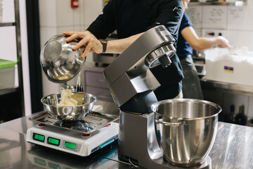 Making macarons. A silver kitchen table mixer kneads the dough for macarons.