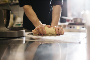 Wall Mural - Close up. The cook kneads the dough with his hands, making macaroons or cakes.