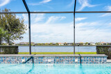 Fototapeta Na ścianę - Modern contemporary home screened glass lanai private pool spa with view of tropical lake in Florida with blue water in clean house
